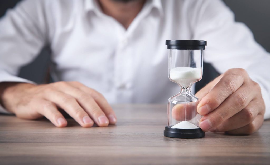 A man uses an hourglass to track the duration of his divorce